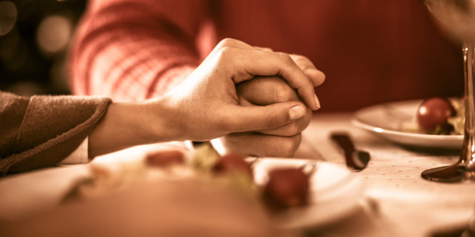 family holding hands at the holiday table