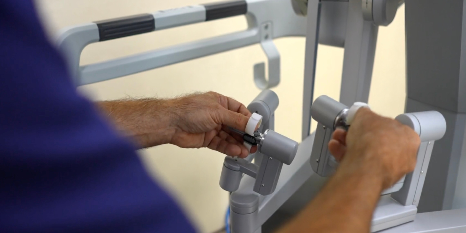 A surgeon uses ginger grips to maneuver instruments and robotic arms during a robotics-assisted procedure.