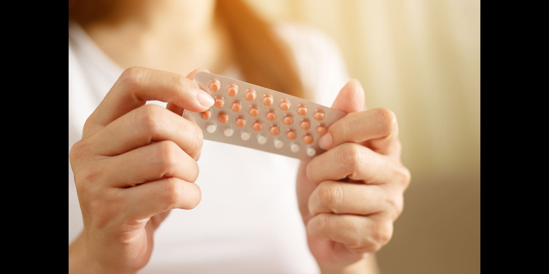 Woman holding birth control pills | Doylestown Health